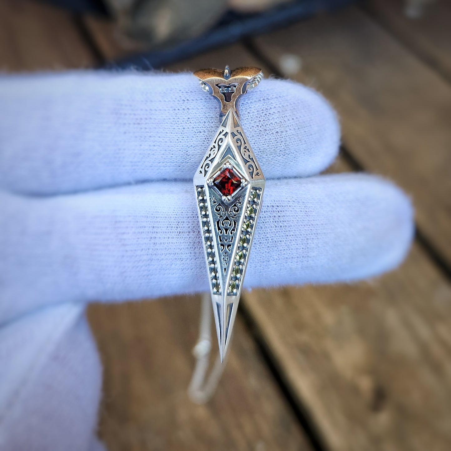 Swinging silver pendant with red garnet and sapphires.